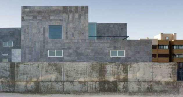 A building clad in stone, conditioned to the environmental conditions of the area