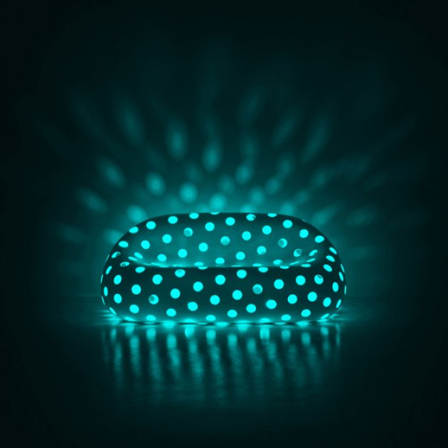 Una moderna butaca de diseño con agujeros que permiten un juego de luz y color 
