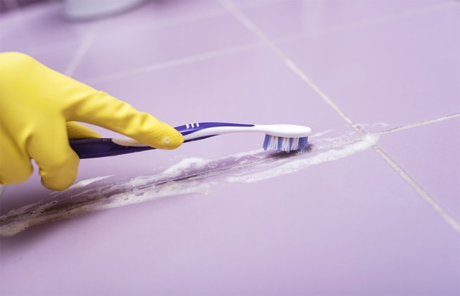 Utilizar un cepillo de dientes para limpiar azulejos